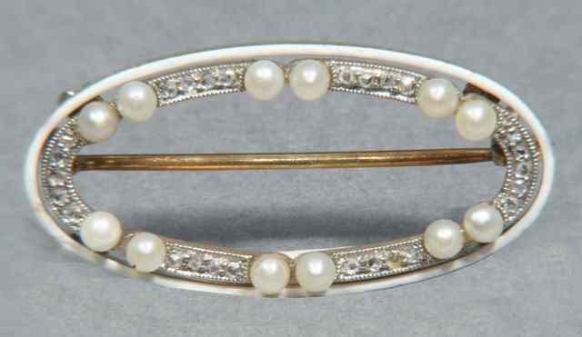 Appraisal: AN EDWARDIAN PEARL DIAMOND AND ENAMELLED BROOCH oval shaped set