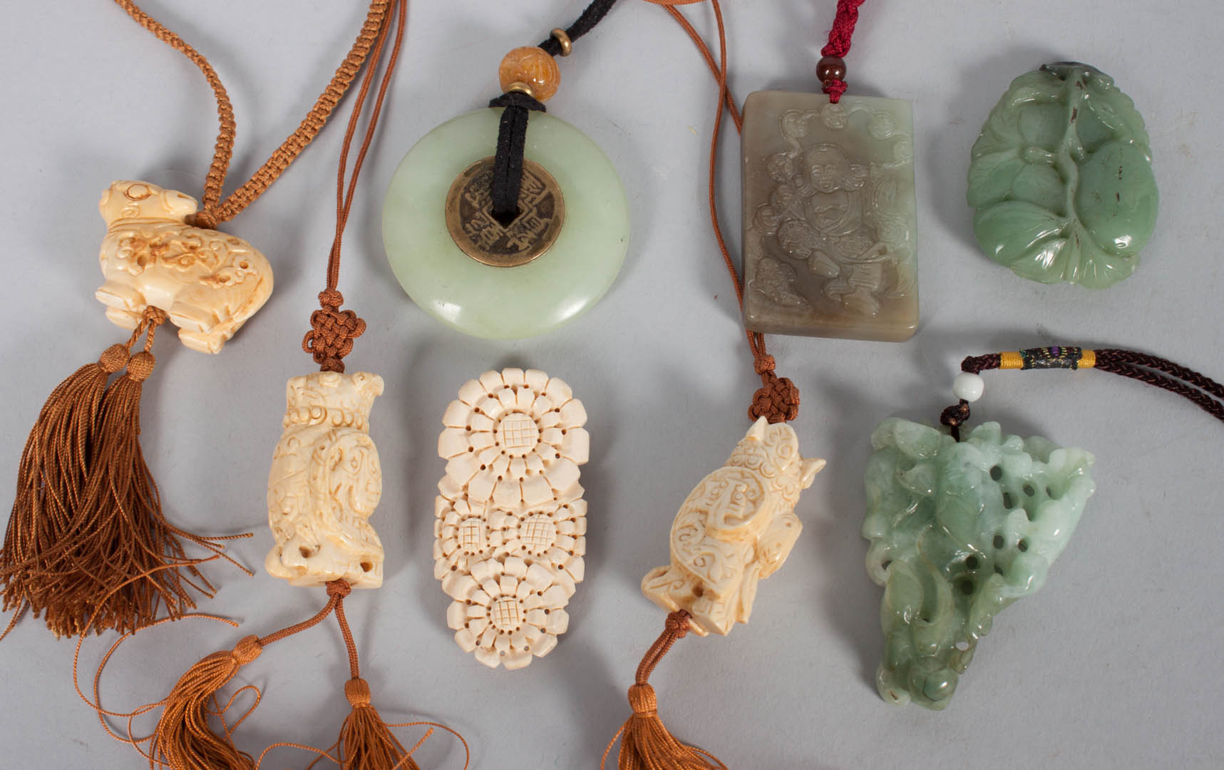 Appraisal: Chinese carved jade and ivory pendants carved ivory pendants and