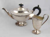 Appraisal: A silver teapot and helmet cream jug in the Adam