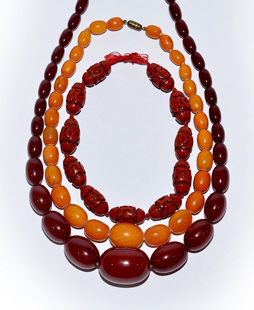 Appraisal: A Chinese burgundy amber necklaceof graduated ovoid beads a yellow