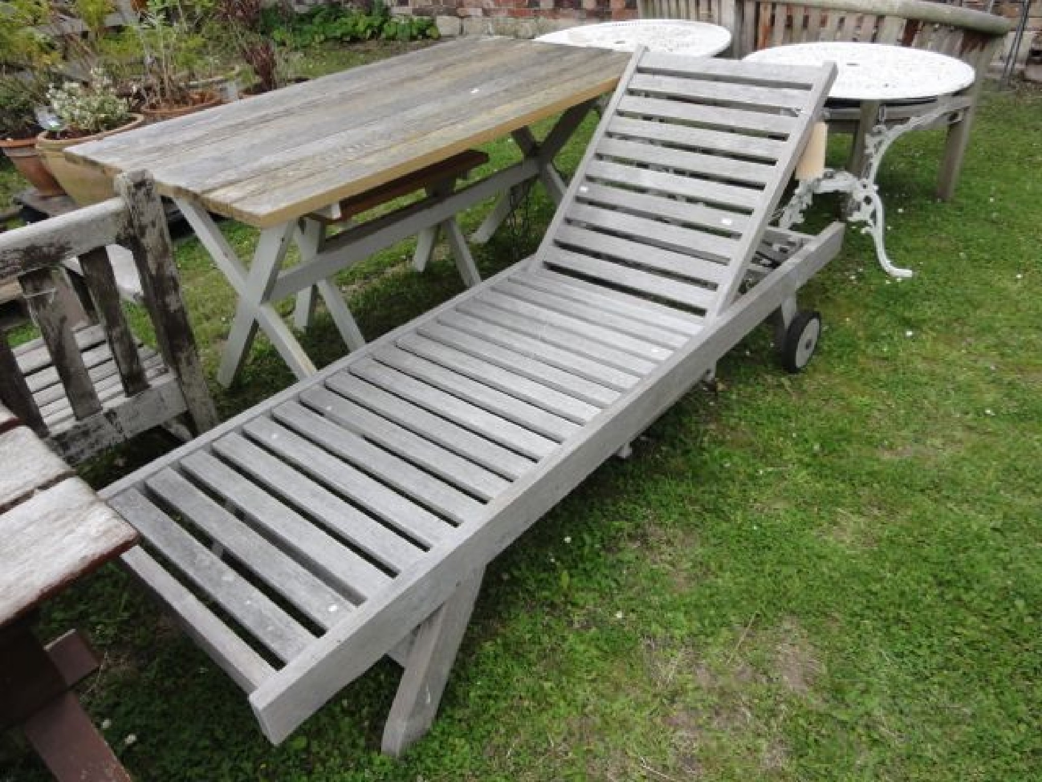 Appraisal: A good quality weathered contemporary teak garden lounger with slatted