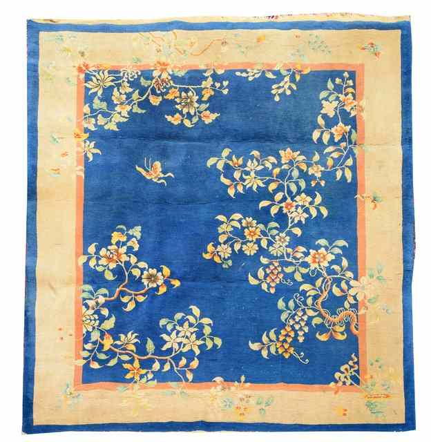 Appraisal: A CHINESE BLUE GROUND CARPET with trailing flower decoration within