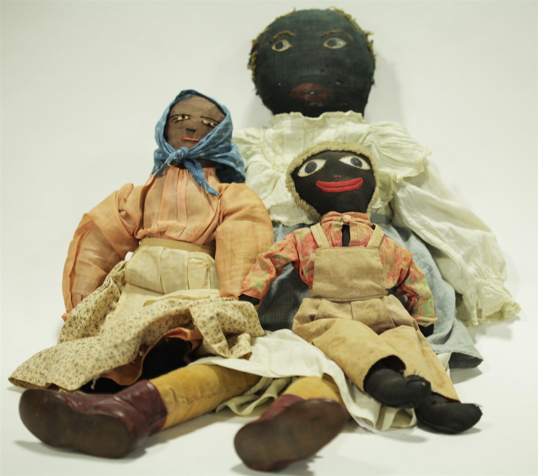 Appraisal: THREE BLACK CLOTH DOLLS WITH PAINTED AND STITCHED FEATURES Late