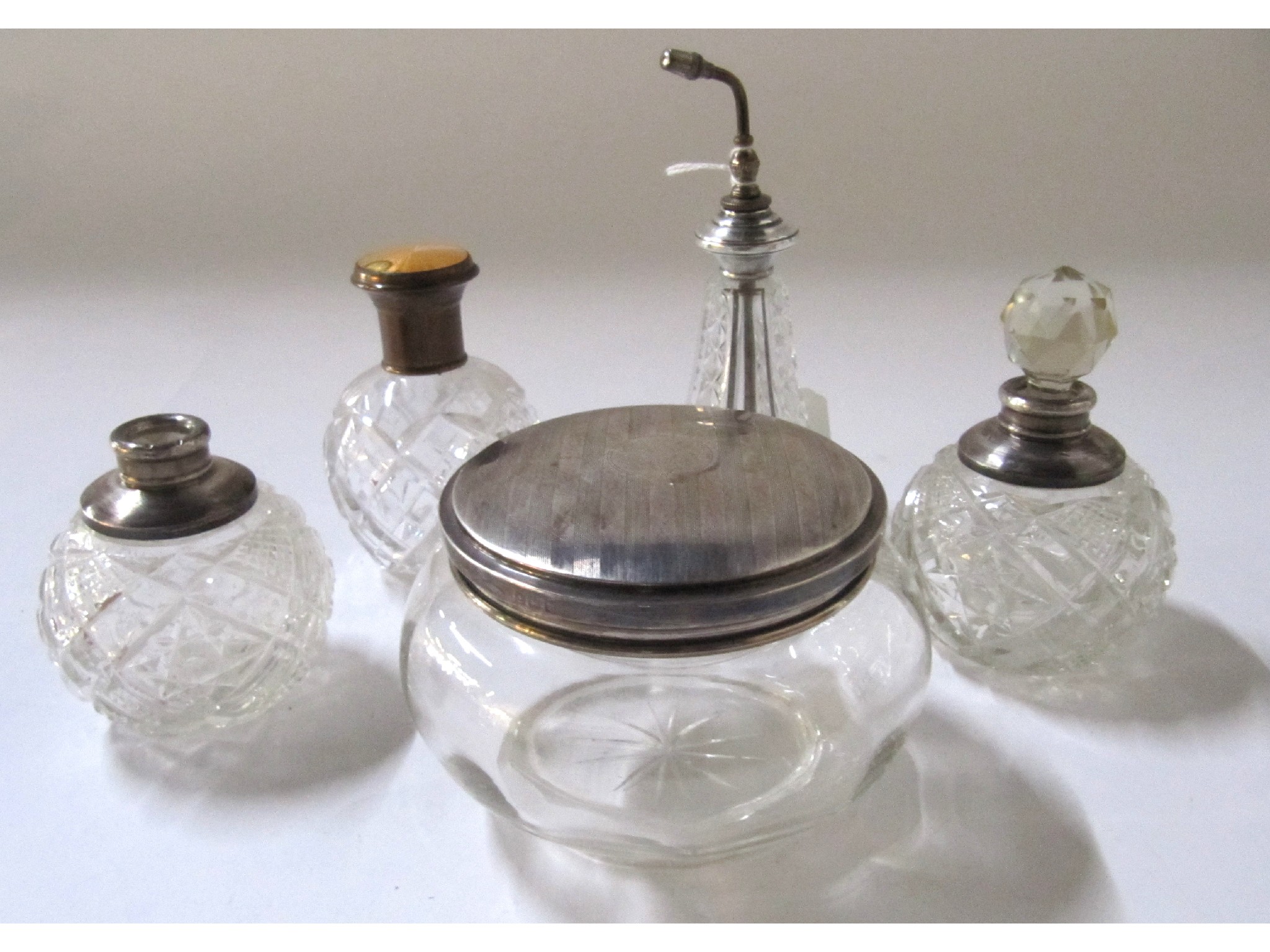 Appraisal: A lot comprising four silver topped and mounted scent bottles