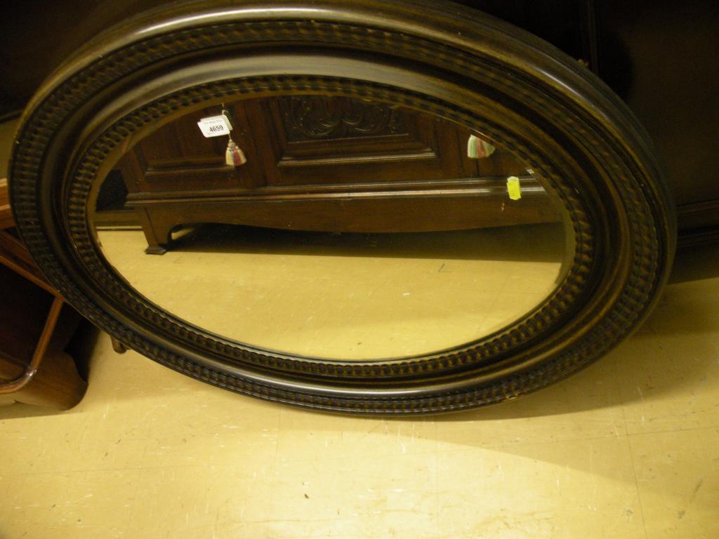 Appraisal: An oval wall mirror with a ripple moulded painted frame