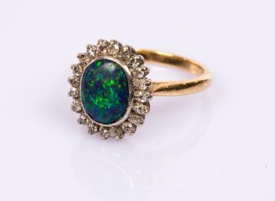 Appraisal: A black opal and diamond cluster ring the oval opal