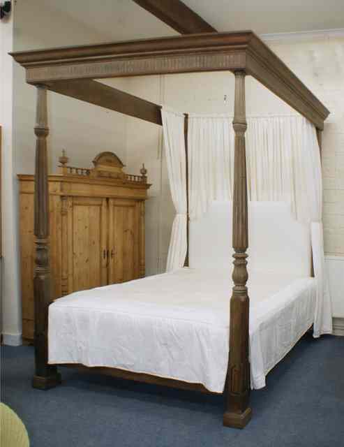 Appraisal: A LARGE HARDWOOD FOUR POSTER BED with moulded and fluted