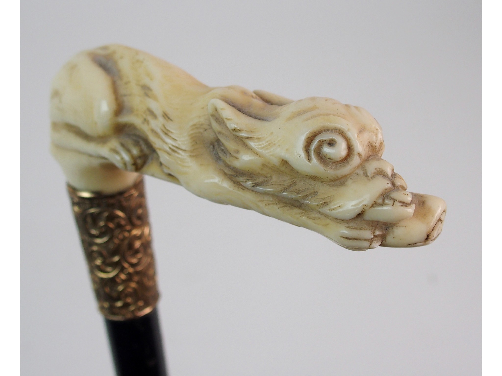 Appraisal: A walking cane with gilt metal mountthe ivory handle modelled