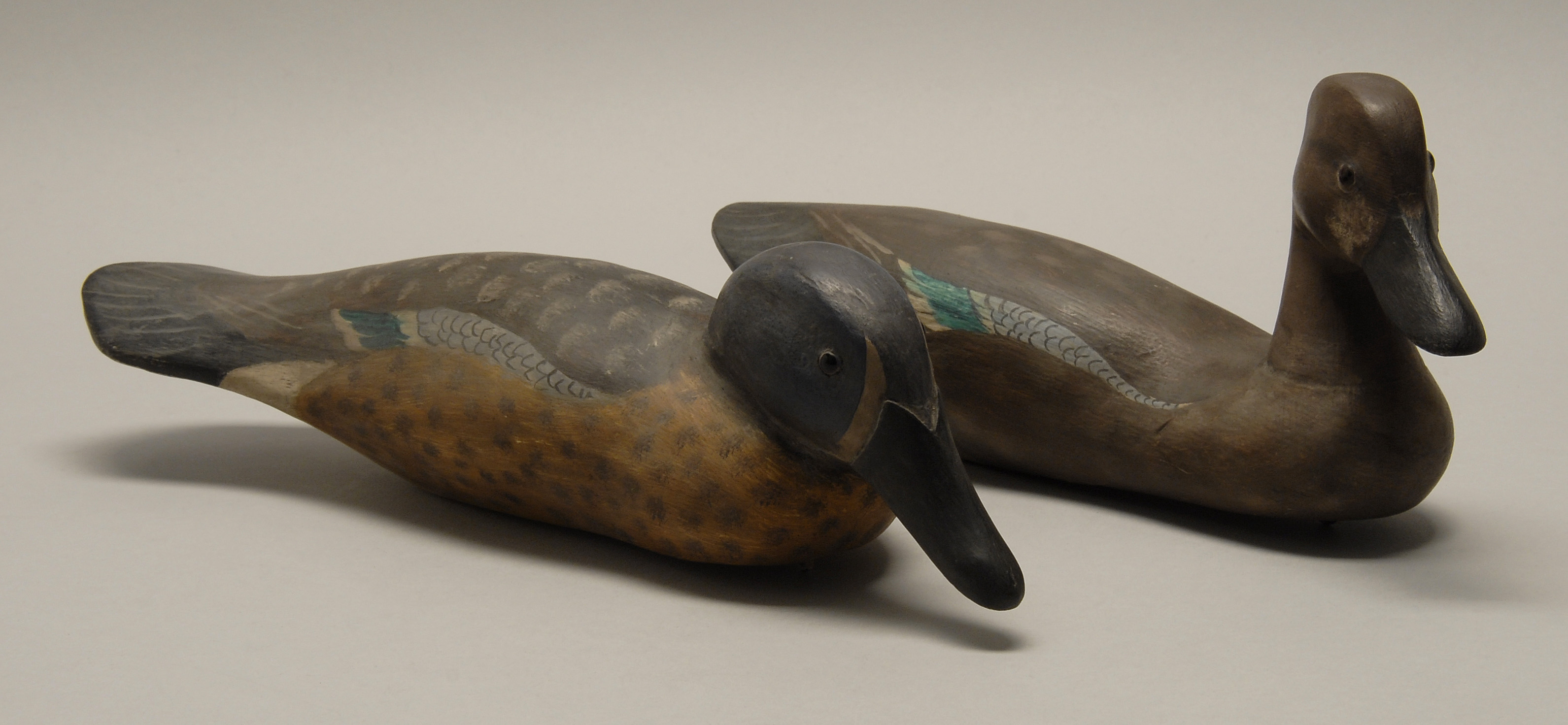 Appraisal: PAIR OF BLUE-WINGED TEAL DECOYS ContemporaryCarved from palm fronds Glass