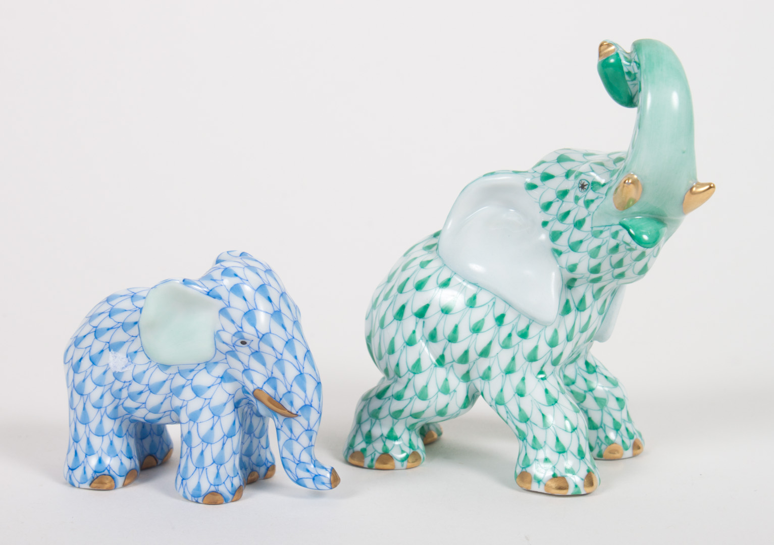 Appraisal: Two Herend porcelain elephants trumpeting elephant in green fishnet pattern