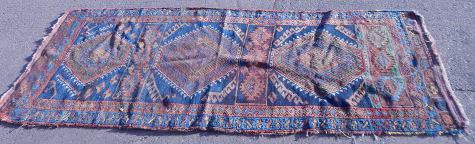 Appraisal: A Persian rug with latchhook medallions on multicoloured ground with