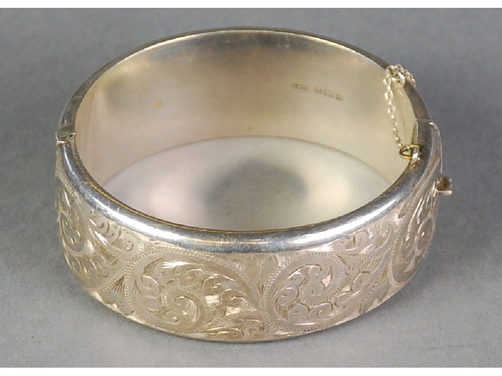 Appraisal: SILVER BROAD HINGE OPENING BANGLE with floral scroll engraved top