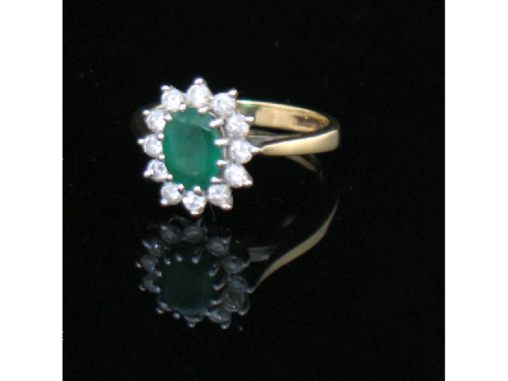 Appraisal: AN EMERALD AND DIAMOND CLUSTER DRESS RING the central oval-cut