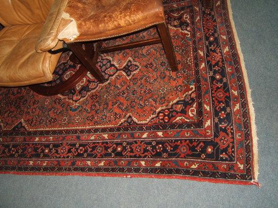 Appraisal: A Persian red ground rug with multiple banded border and