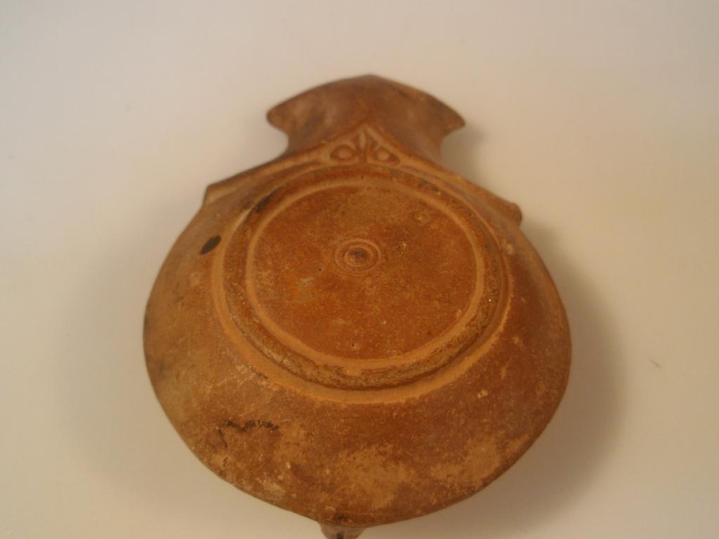 Appraisal: A moulded Roman terracotta oil lamp of shallow closed circular