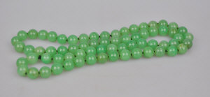 Appraisal: Two strands of green stone uniform beads knotted throughout