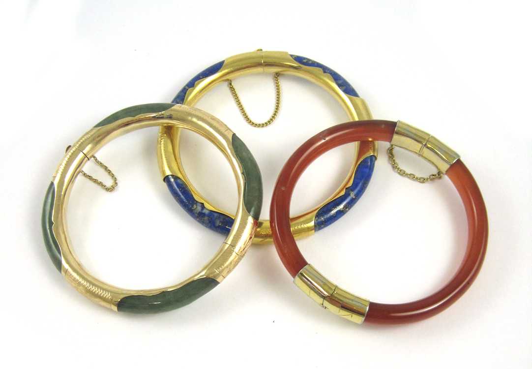 Appraisal: THREE CHINESE GOLD AND HARDSTONE BANGLES blue lapis lazuli and