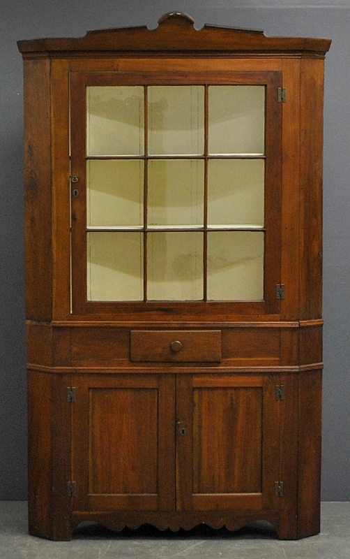 Appraisal: - Pennsylvania two-piece walnut corner cupboard c with a molded