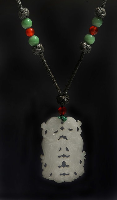 Appraisal: A CHINESE WHITE JADE PENDANT pierced and carved as exotic