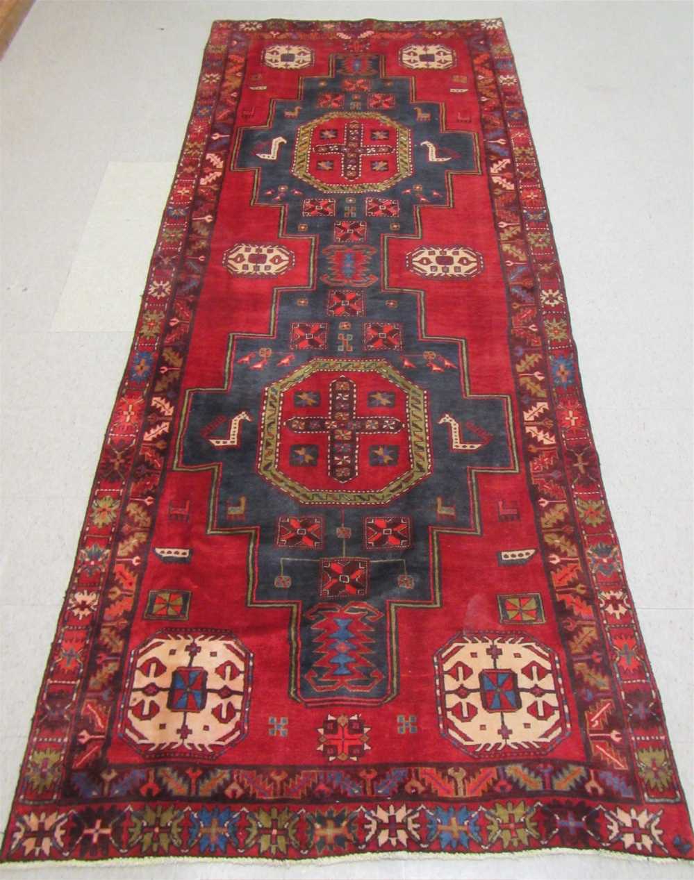 Appraisal: PERSIAN TRIBAL HALL RUG featuring a large pair of dark