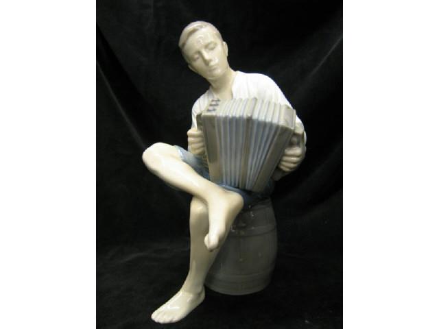 Appraisal: Bing Grondahl Figurine of Boy seated on barrel playing the