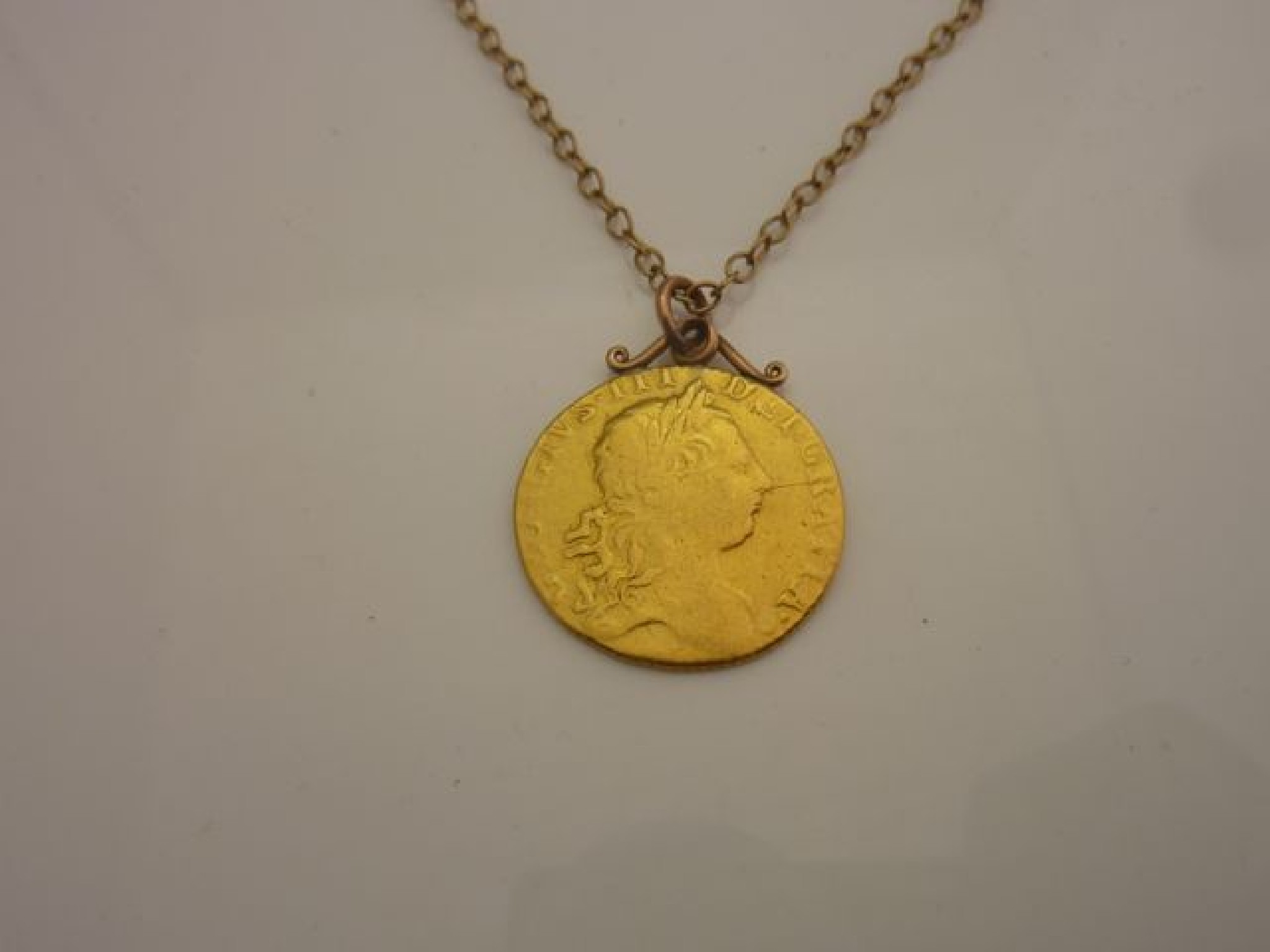 Appraisal: A gold Guinea coin pendant on an unmarked gold curb-link