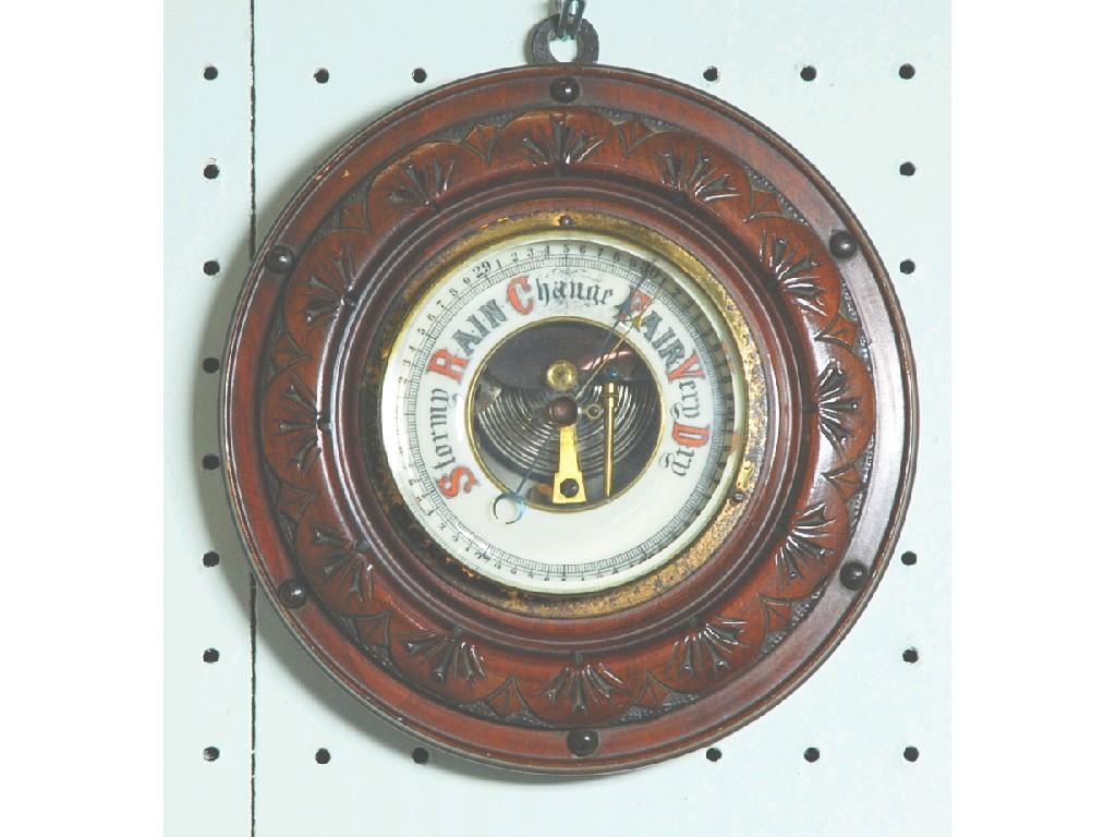 Appraisal: EARLY TWENTIETH CENTURY CARVED WALNUT ANEROID BAROMETER with enamelled register