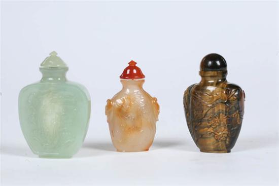 Appraisal: THREE SNUFF BOTTLES All carved stone with matching stoppers -