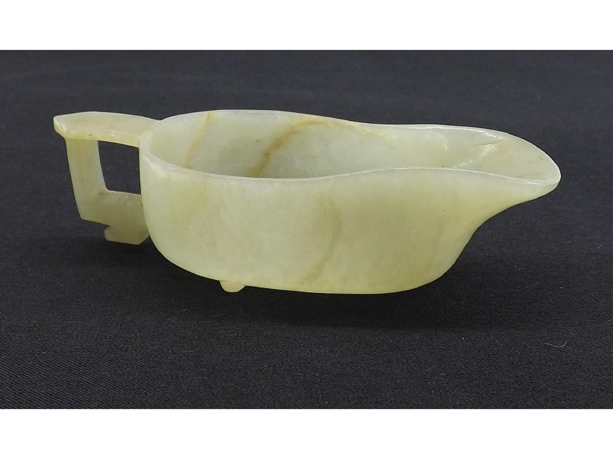 Appraisal: Celadon and light brown veined carved jade modelled as a