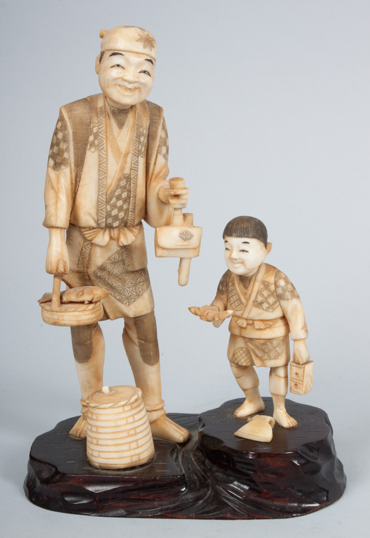 Appraisal: Japanese carved ivory figural group modeled as man and boy