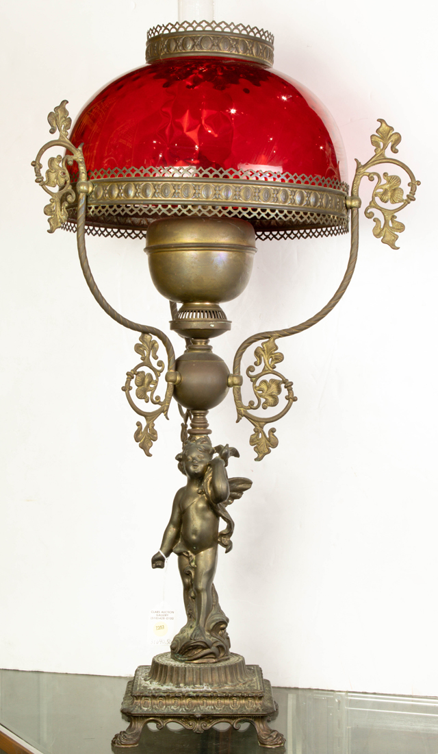 Appraisal: Victorian patinated metal and red glass figural oil lamp attributed