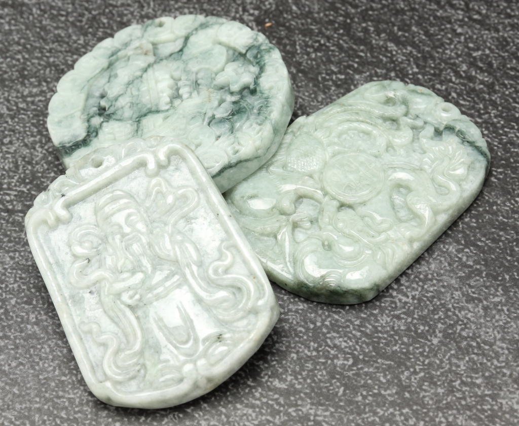 Appraisal: THREE CHINESE CARVED STONE PENDANTS Second half th century Grey