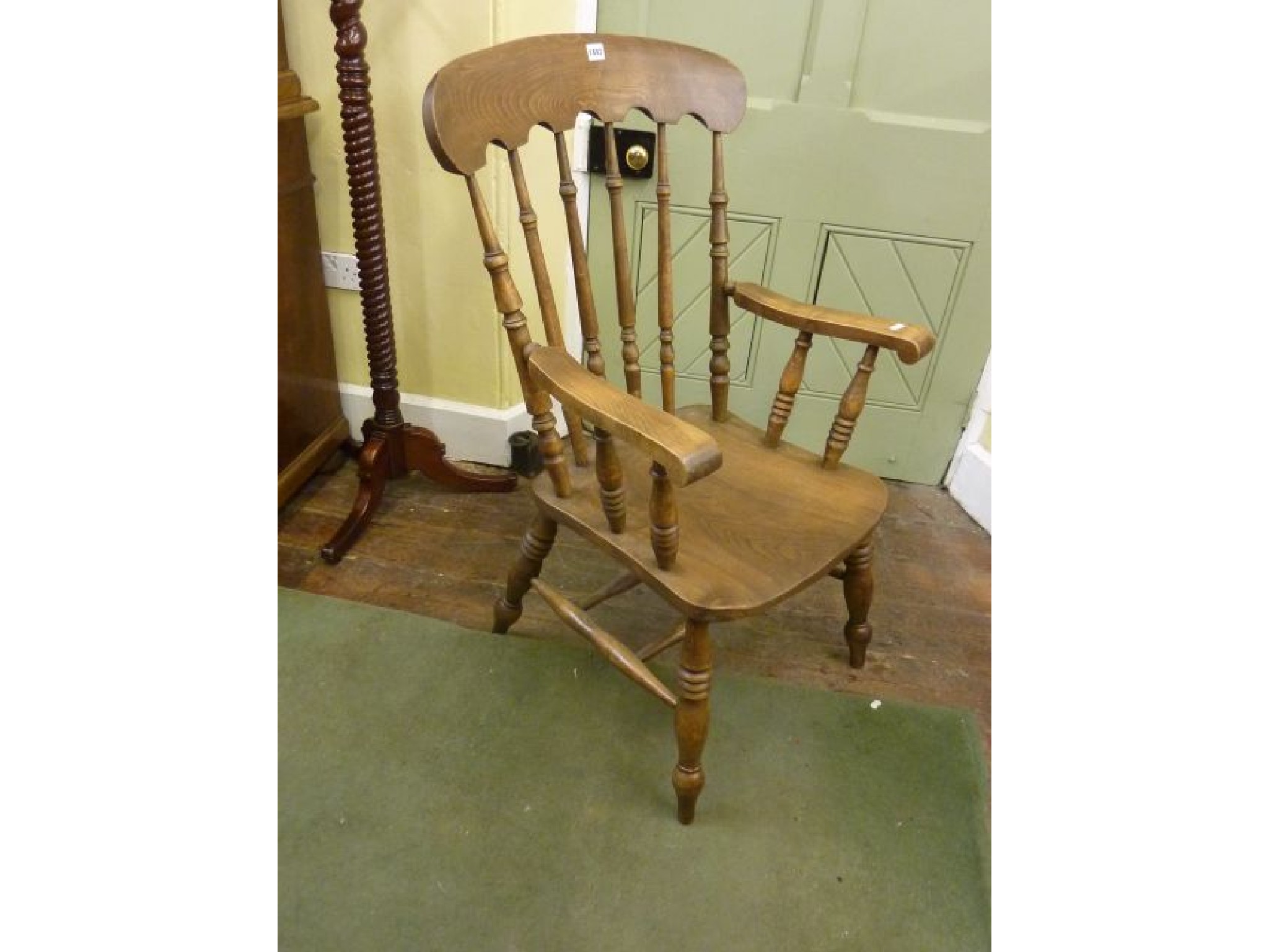 Appraisal: A Windsor elbow chair with turned stickback and scrolled arms