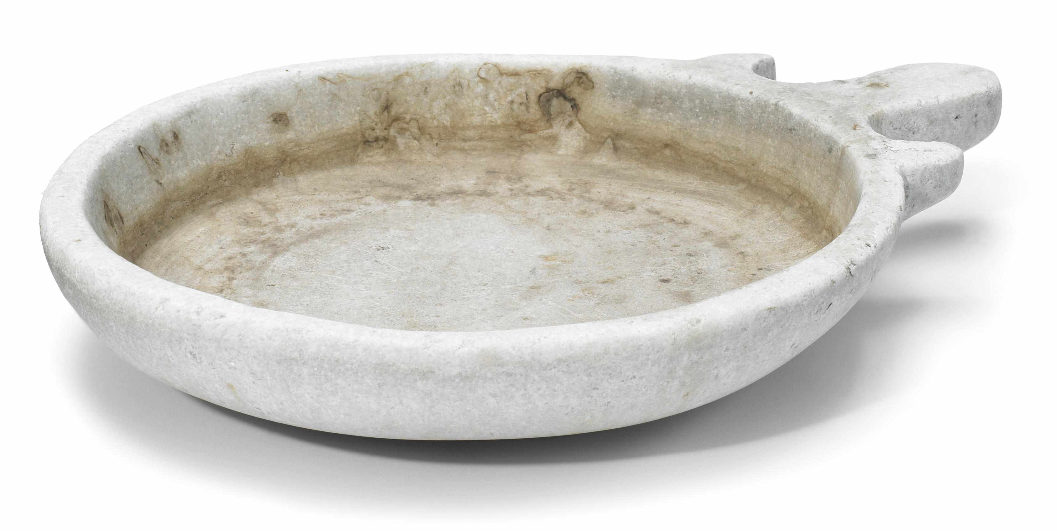 Appraisal: A carved marble shallow circular bowl with shaped handle height