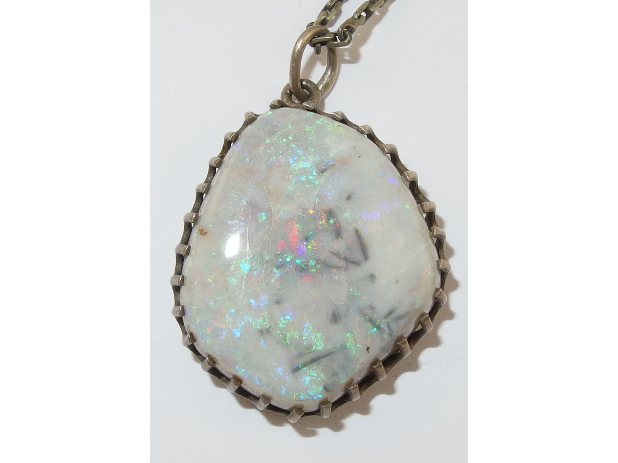 Appraisal: A boulder opal pendantwith a white grey matrix with flashes