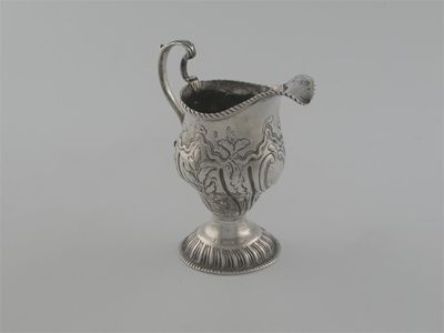 Appraisal: A George III baluster milk jug with embossed decoration and