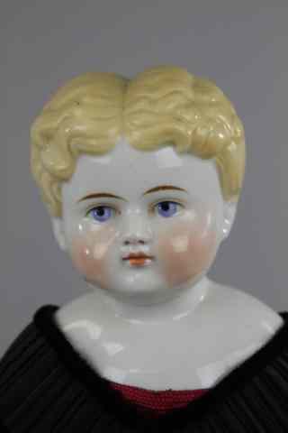 Appraisal: BLONDE CHINA HEAD DOLL RED GOWN Glazed porcelain head with