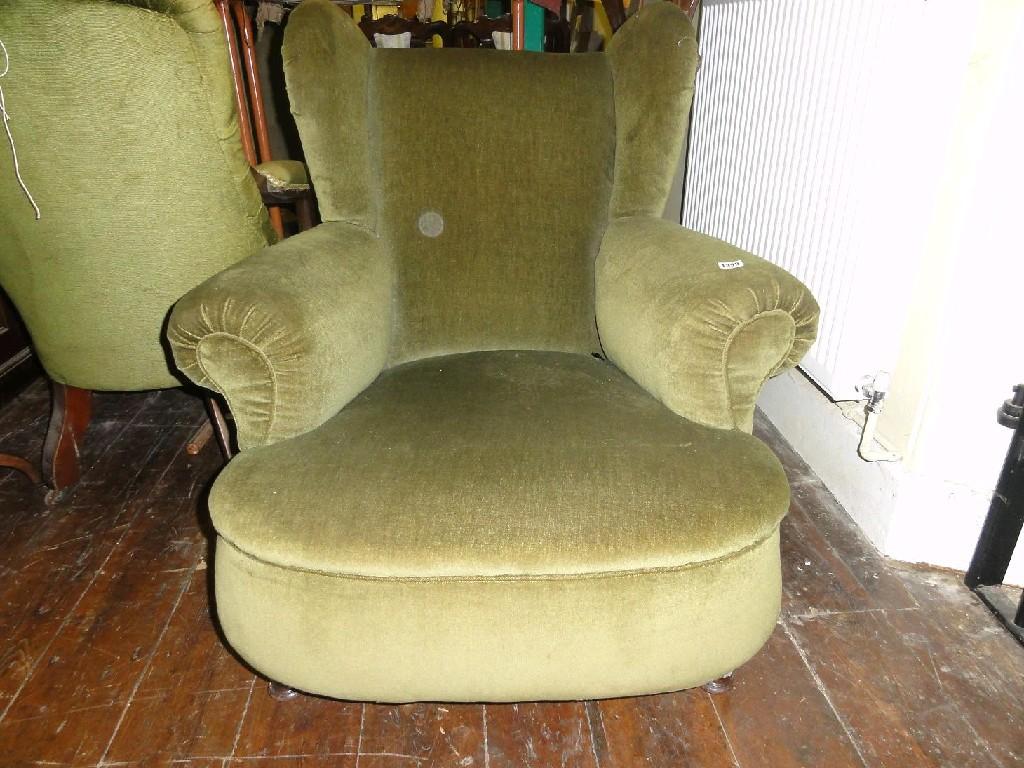 Appraisal: An Edwardian wing back armchair with green velvet upholstered finish