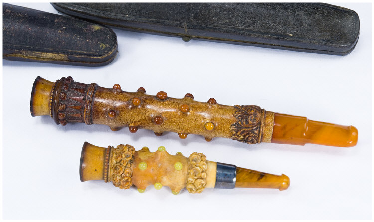 Appraisal: Two Carved Cheroot Holders Both With Amber Mouth Pieces Lengths