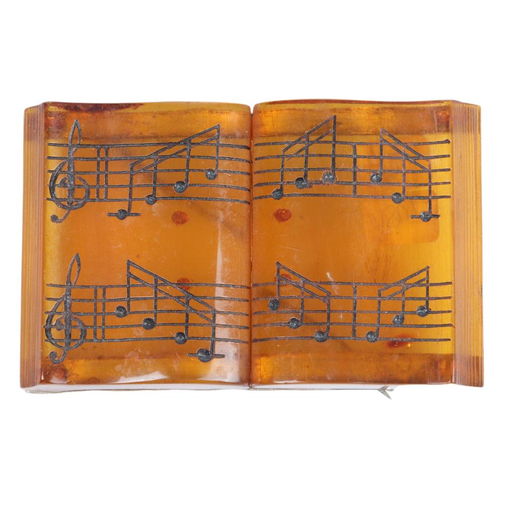 Appraisal: APPLEJUICE BAKELITE SHEET MUSIC BOOK PIN H X WApplejuice Bakelite