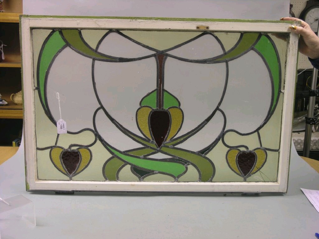 Appraisal: An Art Nouveau stained glass window frame stylised floral design