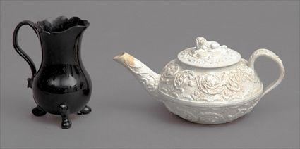 Appraisal: ENGLISH STONEWARE INDIVIDUAL TEAPOT AND A MIRROR BLACK-GLAZED TRIPOD CREAMER