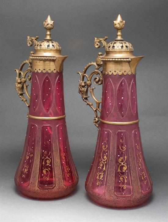 Appraisal: Pair of Bohemian brass-mounted enamel decorated cranberry glass claret jugs