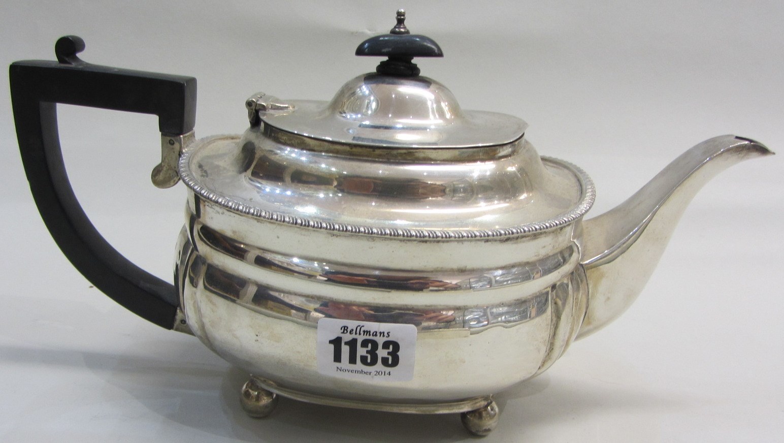 Appraisal: A silver teapot of compressed curved rectangular form decorated with