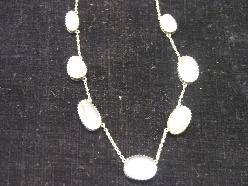 Appraisal: A moonstone necklace seven graduated stones within silver claw settings