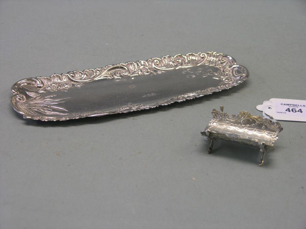 Appraisal: An embossed silver pen tray with 'C' scroll border in