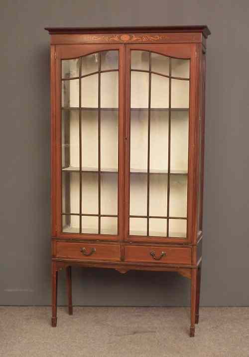 Appraisal: An Edwardian mahogany display cabinet inlaid with boxwood stringings and