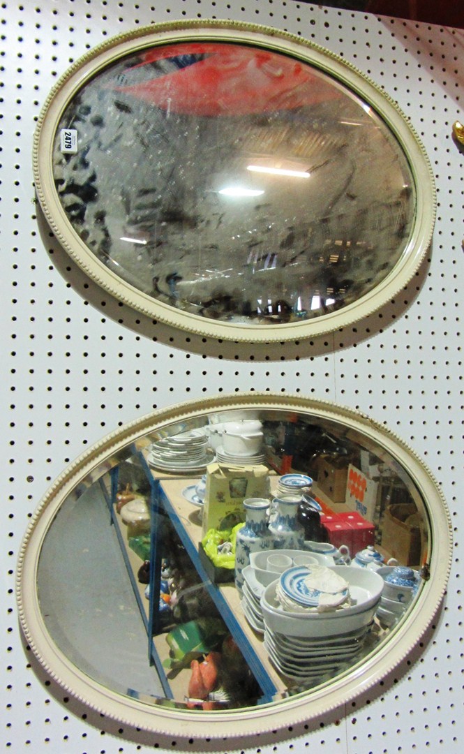 Appraisal: A pair of cream painted oval wall mirrors