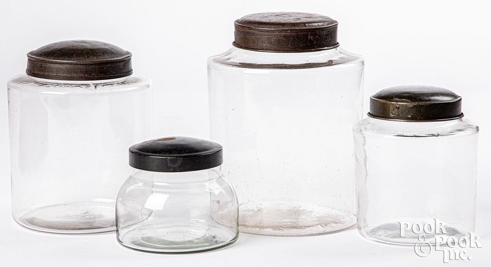 Appraisal: Four tin and colorless glass store counter jars Four tin