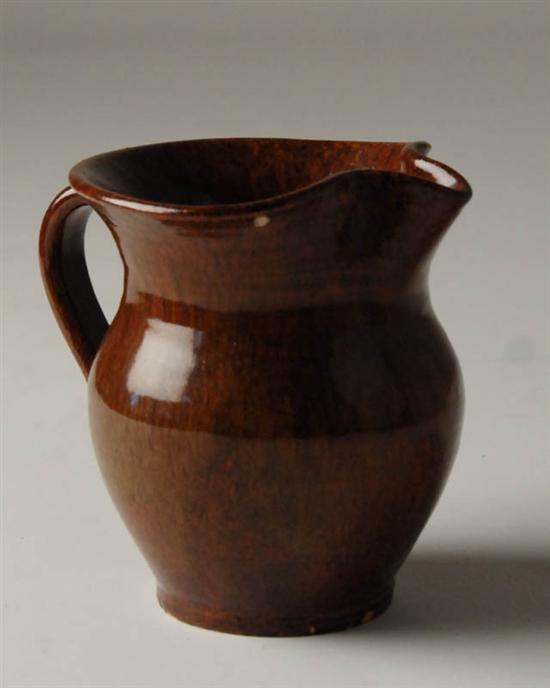 Appraisal: A Monticello Pottery Cream Jug with a brown mottled glaze